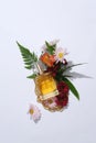 Top view of perfume bottle unbranded displayed with fresh beautiful flowers and green leaves on a white background