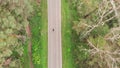 Top view of person in black clothes rides on bike along autumn forest. Professional cyclist is doing hard cardio training on bicyc