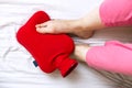 Person with cold feet in bed on a red hot water bottle Royalty Free Stock Photo