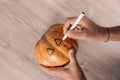 Top view of a person marking a pumpkin for carving it for Halloween