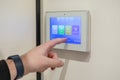 Person interacts with a modern smart home intercom system, touching its vibrant touchscreen display for security and convenient Royalty Free Stock Photo
