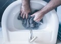 Top view of person washing striped shirt in sink by hand Royalty Free Stock Photo