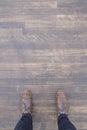 Top view of a person wearing brown Brogue shoes and standing on a wooden floor