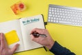 Top view of person writing to-do list on notebook Royalty Free Stock Photo