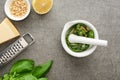 Top view of pesto sauce raw ingredients, grater and pounder on grey surface Royalty Free Stock Photo