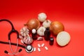 Top view of a phonendoscope next to pills, onions and garlic on a red background Royalty Free Stock Photo