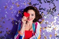 Top view photo of attractive girl lying confetti floor hide face with little valentine day gift isolated vivid color