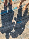 Top view, photo of bare feet and a pair of shadows on a wooden old floor. Photos on vacation, beach, summer