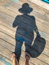 Top view, photo of bare feet and a pair of shadows on a wooden old floor. Photos on vacation, beach, summer