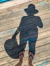 Top view, photo of bare feet and a pair of shadows on a wooden old floor. Photos on vacation, beach, summer Royalty Free Stock Photo