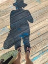 Top view, photo of bare feet and a pair of shadows on a wooden old floor. Photos on vacation, beach, summer Royalty Free Stock Photo