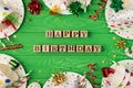 Top view photo of birthday party composition wooden cubes labeled happy birthday ribbon stars spiral candles pipes straws hats