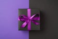 Top view photo of black giftbox with purple ribbon bow on  bicolor violet and black background with copyspace Royalty Free Stock Photo