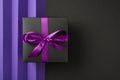 Top view photo of black giftbox with purple ribbon bow on isolated bicolor violet and black background with copyspace Royalty Free Stock Photo