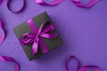 Top view photo of black giftbox with purple ribbon bow sequins and satin ribbon on isolated violet background with copyspace Royalty Free Stock Photo