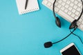 Top view photo of black headset on white keyboard pen on notebook and mobile phone on isolated pastel blue background with blank Royalty Free Stock Photo