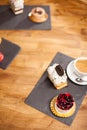 Top view photo of cake with tasty biscuit near different mini cakes on a wooden table in a coffee shop Royalty Free Stock Photo