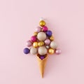 Top view photo of christmas tree balls flying out of ice cream cone on isolated pastel pink background Royalty Free Stock Photo