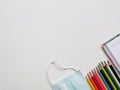 Top view photo of colorful pencil,note book,medical face mask and hand sanitizer isolated on white background. Royalty Free Stock Photo