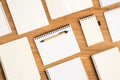 Top view photo of composition of different small and big open planners and pen on isolated wooden desk background with empty space