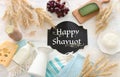 Top view photo of dairy products over white wooden background. Symbols of jewish holiday - Shavuot