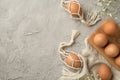 Top view photo of easter decorations brown easter eggs in wooden egg holder and string bags cloth and white gypsophila flowers on Royalty Free Stock Photo