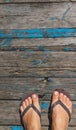 Top view, photo of female legs in beach flip flops on a wooden old floor. Photos on vacation, beach, summer Royalty Free Stock Photo