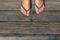 Top view, photo of female legs in beach flip flops on a wooden old floor. Photos on vacation, beach, summer Royalty Free Stock Photo