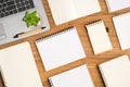 Top view photo of flowerpot and pen on laptop and composition of different rectangular small and big copybooks on isolated wooden