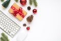 Top view photo of gift box with red bow keyboard computer mouse pen red christmas tree balls fir toy pine twigs cones and anise on Royalty Free Stock Photo