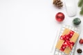 Top view photo of gift box with red bow on keyboard computer mouse pen red christmas tree balls fir toy twig pine cone on isolated Royalty Free Stock Photo