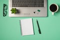 Top view photo of green and black binder clips flowerpot on laptop keyboard glasses cup of coffee pen and spiral notebook on