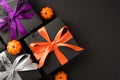 Top view photo of halloween composition three black gift boxes with violet orange and white ribbon bows small pumpkins spiders and Royalty Free Stock Photo