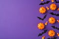 Top view photo of halloween decorations small pumpkins candy corn and bats silhouettes on isolated violet background with