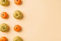 Top view photo of halloween decorations two rows of orange and golden small pumpkins on isolated beige background with copyspace Royalty Free Stock Photo