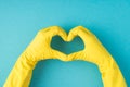 Top view photo of hands in yellow rubber gloves making heart with fingers on  pastel blue background with blank space Royalty Free Stock Photo