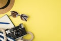 Top view photo of headwear sunglasses beach bag with blue open diary pen and camera on isolated yellow background with copyspace Royalty Free Stock Photo