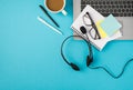 Top view photo of laptop headphones with microphone cup of tea pens glasses on planner and sticker notes on isolated pastel blue Royalty Free Stock Photo