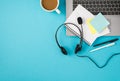 Top view photo of laptop headset with microphone cup of coffee pens copybook and sticker notes on isolated pastel blue background Royalty Free Stock Photo