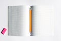 Top view photo of a notebook with checkered pages, with a yellow pencil and a pink eraser lying on it Royalty Free Stock Photo