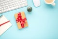 Top view photo of notebook pen giftbox with red bow keyboard computer mouse pine toy and cup of hot drinking on isolated pastel Royalty Free Stock Photo