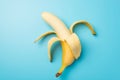 Top view photo of one peeled ripe banana in the middle on isolated pastel blue background Royalty Free Stock Photo