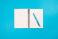 Top view photo of open blue reminder and pen on isolated pastel blue background