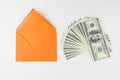 Top view photo of orange envelope and heap of dollars on white Royalty Free Stock Photo