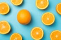 Top view photo of orange slices and one whole orange water drops on isolated light blue background Royalty Free Stock Photo