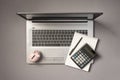 Top view photo of piggy bank moneybox calculator pen and reminder on open grey laptop on isolated grey background