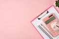 Top view photo of piggybank on pink calculator clipboard planner pen and plant on isolated pastel pink background with copyspace Royalty Free Stock Photo