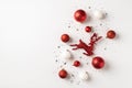 Top view photo of red and white christmas tree decorations balls reindeer and silver confetti on isolated white background with Royalty Free Stock Photo