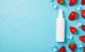 Top view photo of scattered strawberries ice cubes water drops and white sprayer container without label on isolated light blue Royalty Free Stock Photo