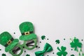 Top view photo of the shimmer Irish spectacles with hats silk green bow tie two stripped straws and green confetti in shape of Royalty Free Stock Photo